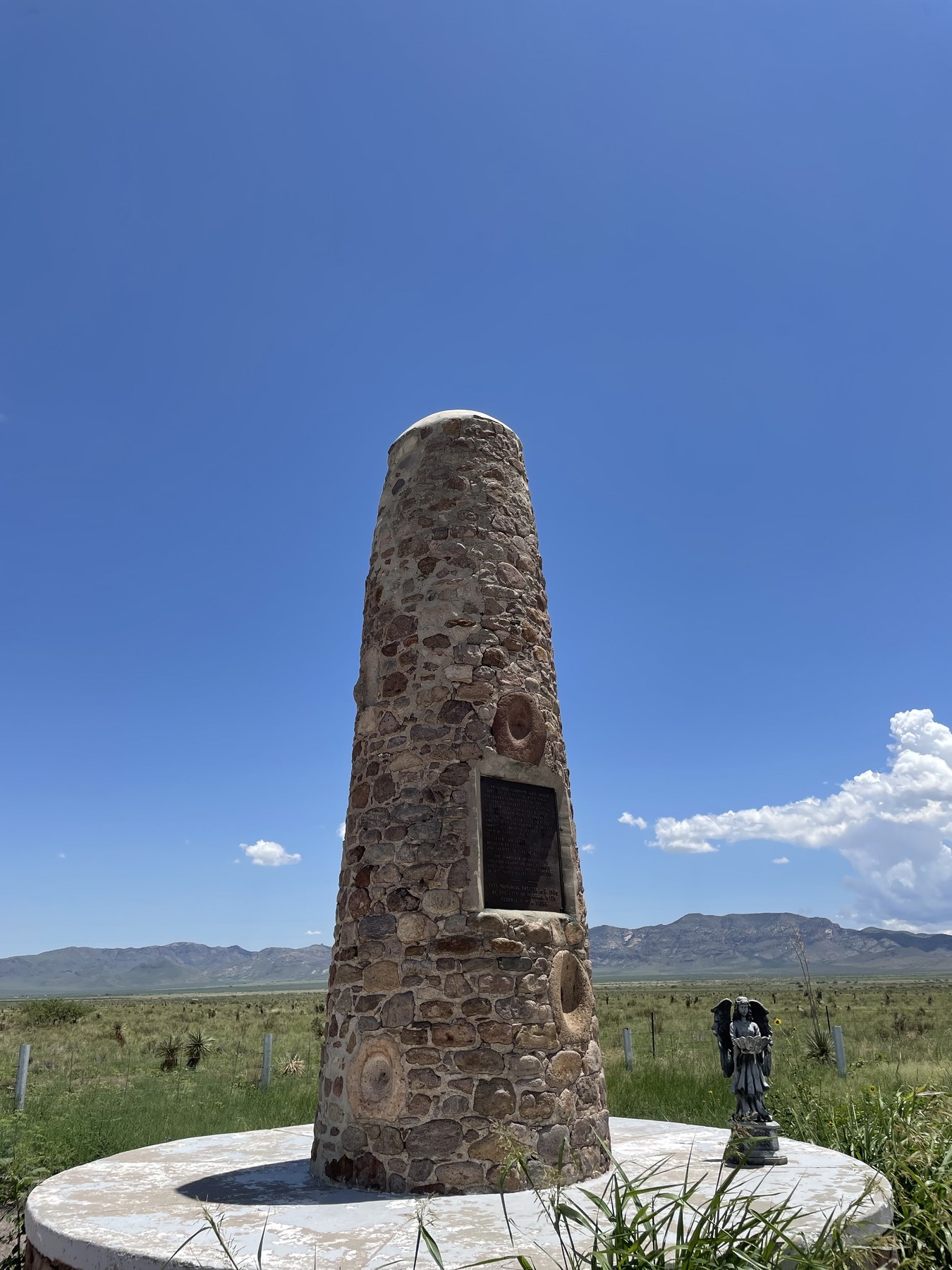Serafina near a stone desert marker with mountains behind her.